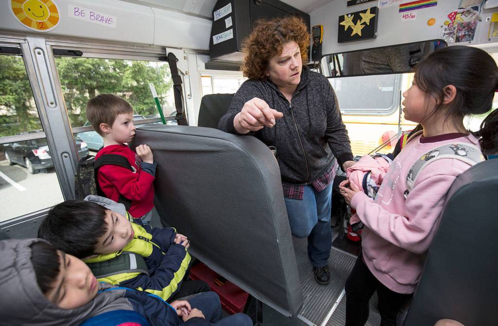 Concerned about a ill student, bus driver Jenny Firoved talks with Hilltop Elementary student Isabel Han as she boards the bus for home on Wednesday in Lynnwood. (Andy Bronson / The Herald)