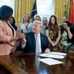 President Donald Trump hands a pen to Yvonne Ambrose, who lost her 16-year-old daughter Desiree Robinson, after signing a new law aim at curbing sex trafficking, in the Oval Office of the White House on Wednesday in Washington. (AP Photo/Evan Vucci)