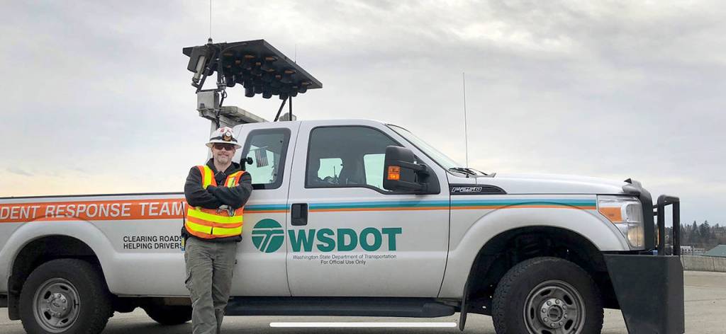 Trent Galusha stands next to the Incident Response Team truck he drives for his job with the Washington State Department of Transportation. (WSDOT photo)