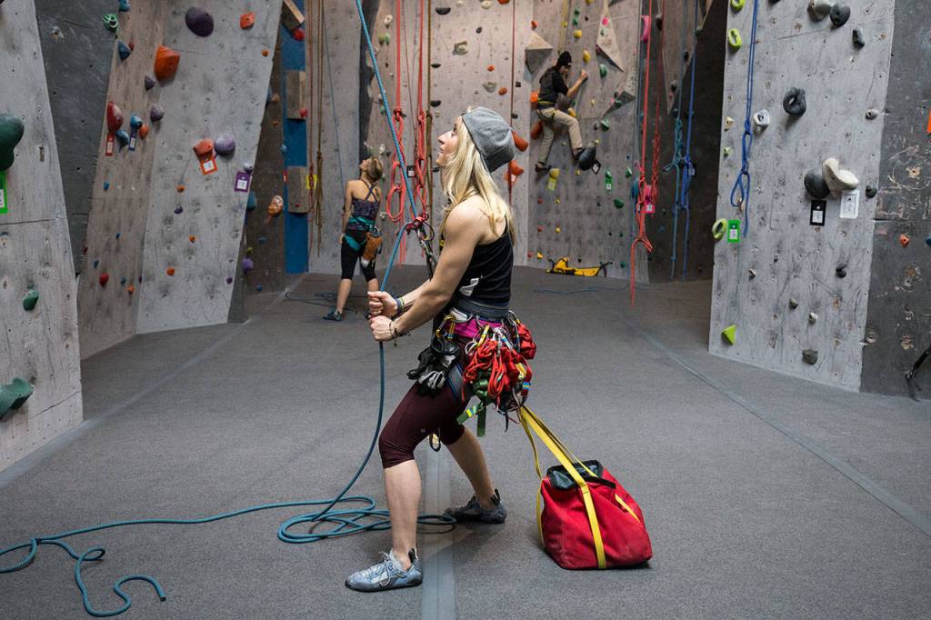 Anna Meehan uses a ballast bag to anchor herself while belaying another heavier climber at Summit Everett on Wednesday. (Andy Bronson / The Herald)