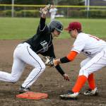 Jacksons Diego Altamirano (left) avoids the tag at third base by Cascades Jacob Sesso during a game on April 11, 2018, at Cascade High School in Everett. (Andy Bronson / The Herald)