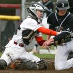 Cascades Nicholas Klemp (left) tags out Jacksons Diego Altamirano during a game on April 11, 2018, at Cascade High School in Everett. (Andy Bronson / The Herald)