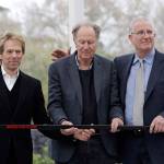 Part owners Jerry Bruckheimer (left) and David Bonderman (center) pose with Tod Leiweke and a hockey stick during a news conference naming Leiweke as the president and CEO for a prospective NHL expansion team on April 11, 2018, in Seattle. (AP Photo/Elaine Thompson)