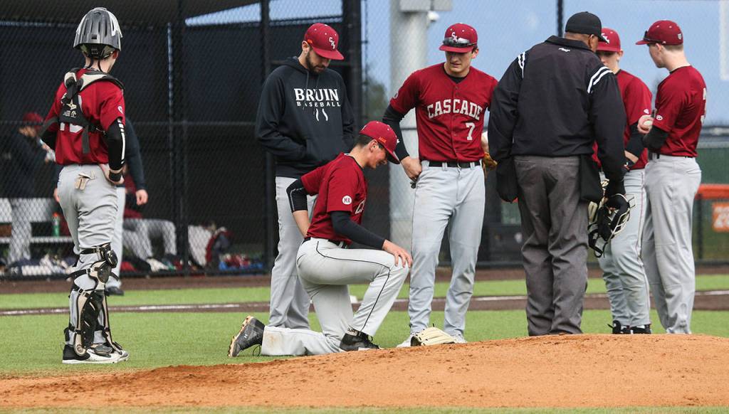 Teammates and coaches surround Cascade pitcher Brock Gillis after he took a line drive to the back during a game against Monroe on April 17, 2018, in Monroe. (Andy Bronson / The Herald)