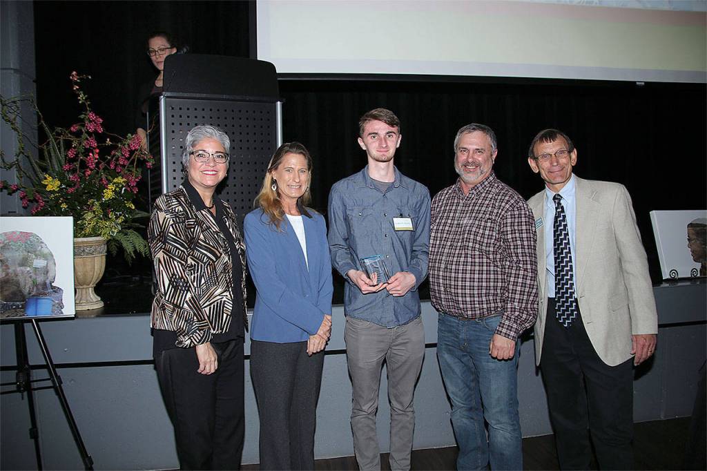 Jarrett Delfel (center) receives a Youth Conservation Leader of the Year award. Hes pictured with, from left, Maia Bellon, Washington Department of Ecology director, Stephanie Wright, Snohomish County Council chair, Mark Craven, Snohomish Conservation District Board chair, and Monte Marti, SCD district manager. (Contributed photo)