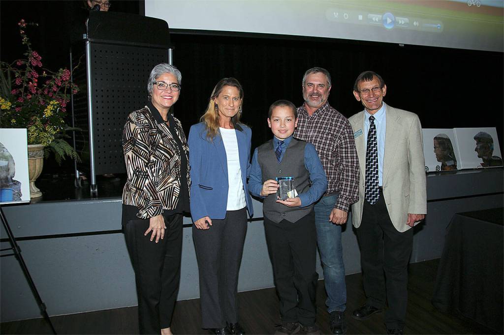 James Osborn (center) receives a Youth Conservation Leader of the Year award. Hes pictured with, from left, Maia Bellon, Washington Department of Ecology director, Stephanie Wright, Snohomish County Council chair, Mark Craven, Snohomish Conservation District Board chair, and Monte Marti, SCD district manager. (Contributed photo)