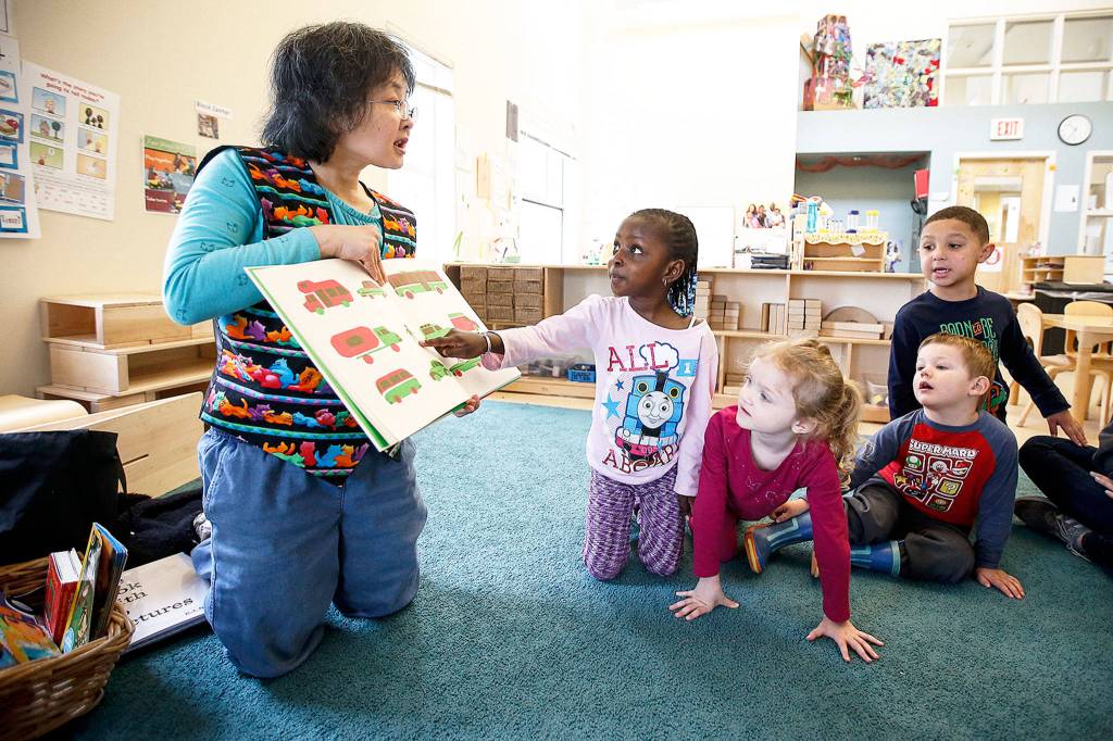 Marianne Le (left), a librarian at Everett Community College, reads to preschoolers (from left) Ayesha, Rylee, Dante and Isaiah at the schools Early Childhood Education and Assistance Program in Everett on April 6. (Ian Terry / The Herald)