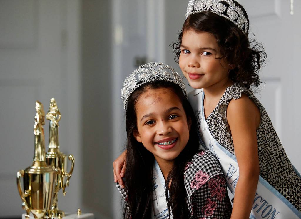 Isabelle Hansen (left), 8, and Aria Hansen, 4, put on their tiaras and Miss Washington Princess Swashes. Read the <a href="http://www.heraldnet.com/news/curtsying-is-optional/" target="_blank">story</a>. (Dan Bates / The Herald)
