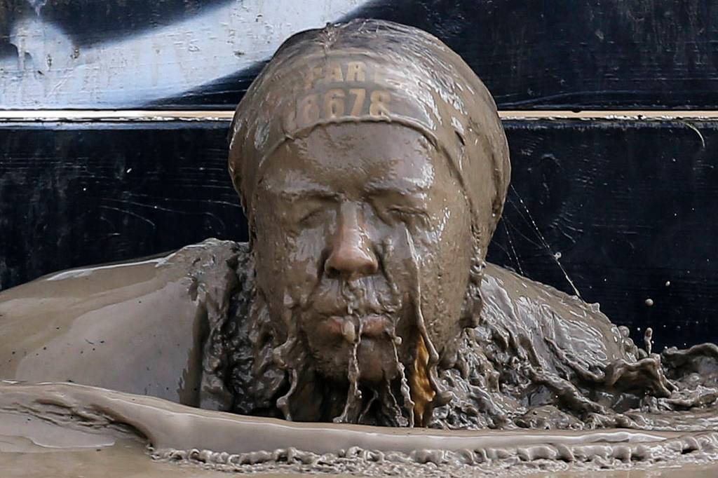 A race participant emerges from the muddy water at the Spartan Race and Sprint in Snohomish on April 15. (Kevin Clark / The Herald)