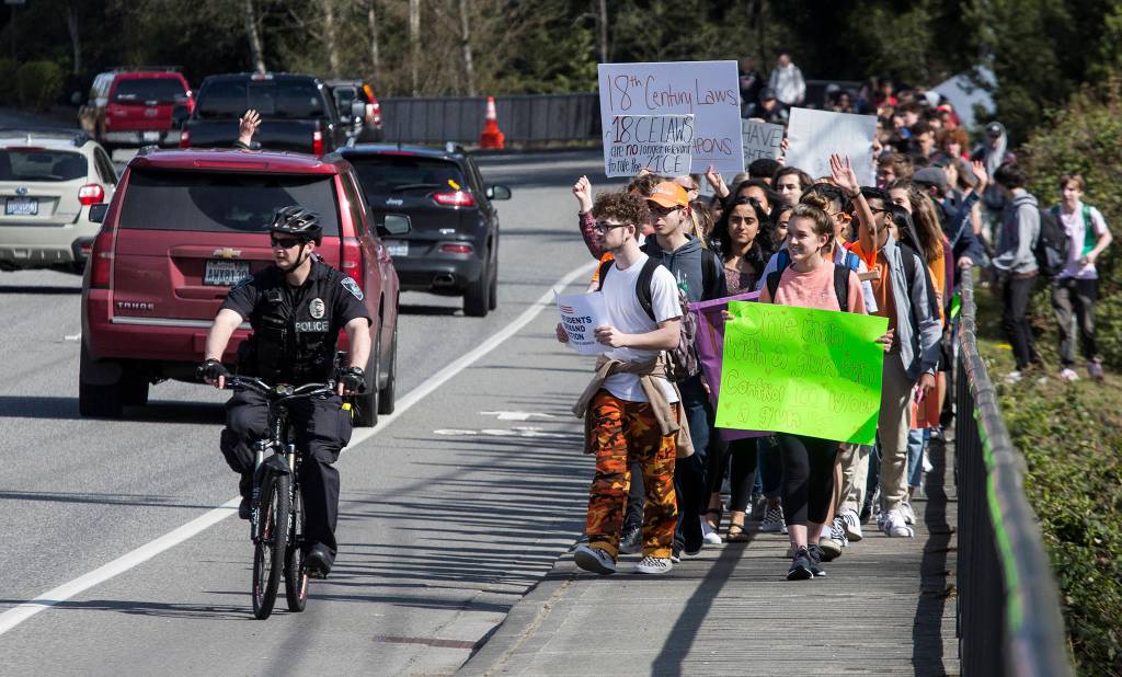 Drivers honk and wave as Jackson High students walk along the Bothell Everett Highway to city hall during the National School Walkout on April 20 in Mill Creek. (Andy Bronson / The Herald)