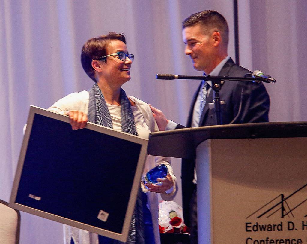 Everett Mayor Cassie Franklin, former CEO of Cocoon House, receives the agencys Chrysalis Award from its new CEO, Joe Alonzo. (Dan Bates / The Herald)