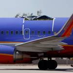In this April 4, 2011 photo, a Southwest Airlines plane sits in a remote area of the Yuma International Airport, after the plane had a section of fuselage tear from the plane during a flight in Yuma, Arizona. (AP Photo/Ross D. Franklin, File)