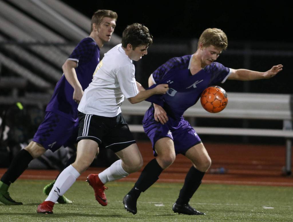 Lake Stevens Jacob Woodward grabs the jersey of Kamiaks Marcus Swanson as they battle for the ball on Tuesday, April 24, 2018 in Lake Stevens, Wa. (Andy Bronson / The Herald)