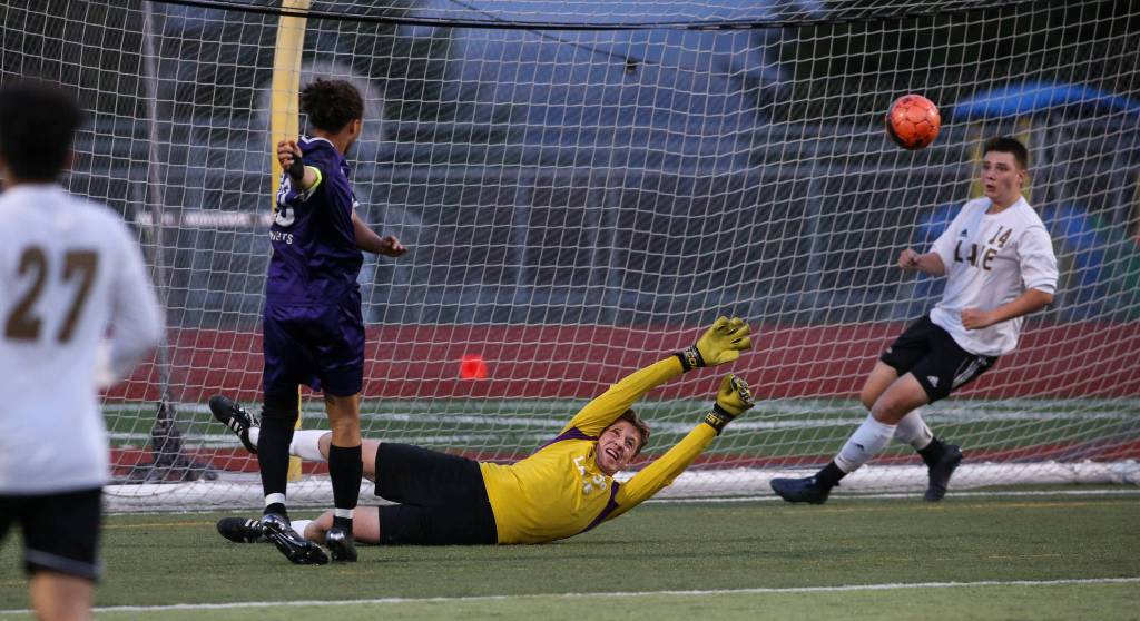 Kamiaks Andre Hamilton kicks the ball past Lake Stevens goalie JJ Smith as Kamiak beat Lake Stevens 2-1 in a soccer match on April 24 in Lake Stevens. (Andy Bronson / The Herald)