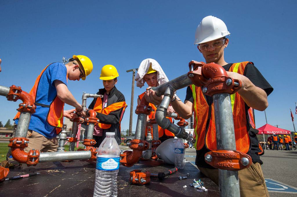 Marysville Getchell students (L-R) Niklas Vieth, Adair Sanchez, Jordan Valencia and RJ Bancroft assemble a sprinkler system at the <a href="http://www.heraldnet.com/news/skilled-trades-get-their-day-at-school/" target="_blank">Trade Up event at Marysville Pilchuck High School</a> on April 26 in Everett. (Andy Bronson / The Herald)
