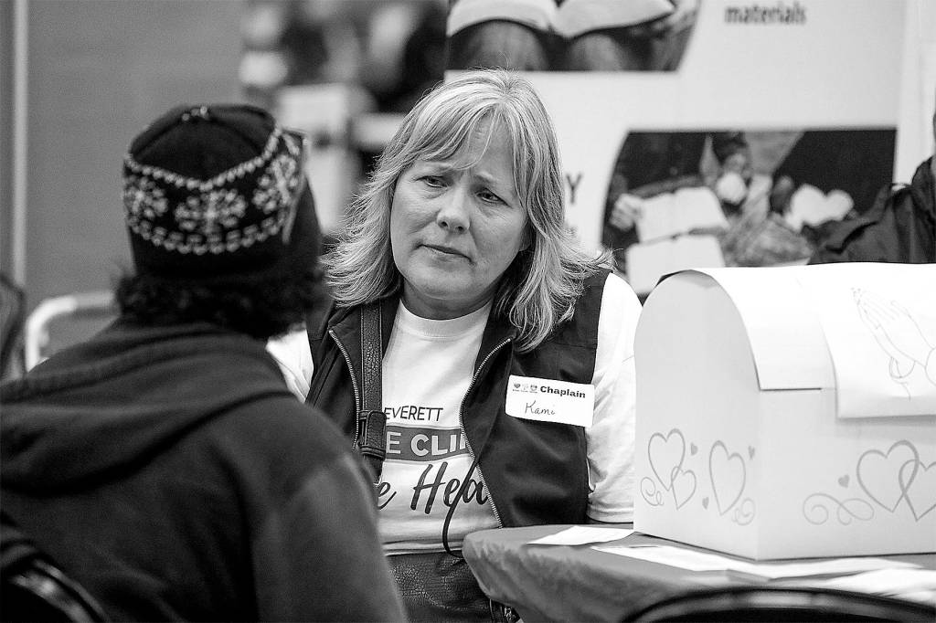 Photo by Heidi Baumgartner                                Chaplain Kami Borg, of Everett, listens to a prayer request at the free AMEN health clinic held April 20 and 22 at Angel of the Winds Arena in downtown Everett.
