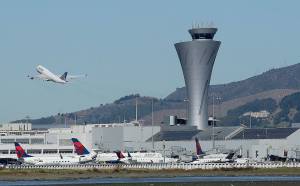 The air traffic control tower is in sight as a plane takes off from San Francisco International Airport in San Francisco in 2017. (AP Photo/Jeff Chiu)