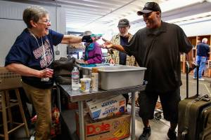 Volunteer Pat Reeve, 78, gets a sweet response when she surprises Samuel Williford, 63, of Everett, with something to eat Wednesday at the Everett Food Bank. Reeve has volunteered there 10 years. Its addictive in a way, she said. Its my family. (Dan Bates / The Herald)