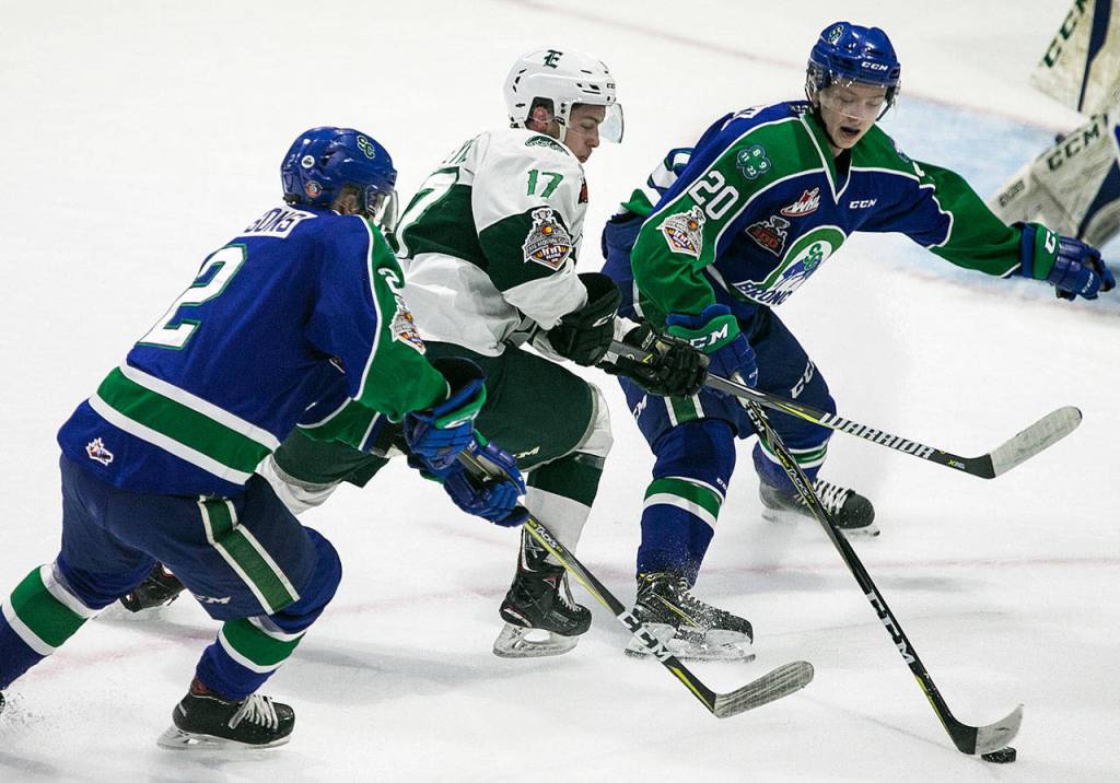 Swift Currents Colby Sissons (left) and Aleksi Heponiemi (right) defend against the Silvertips Matt Fonteyne in the first period of Game 4 of the WHL finals on May 9, 2018, at Angel of the Winds Arena in Everett. (Kevin Clark / The Herald)