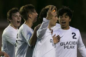 Glacier Peaks Keegan Rubio celebrates his second goal with two fingers and teammates against Mount Vernon during the 4A district championship Thursday night at Goddard Stadium in Everett on May 10, 2018. (Kevin Clark / The Herald)