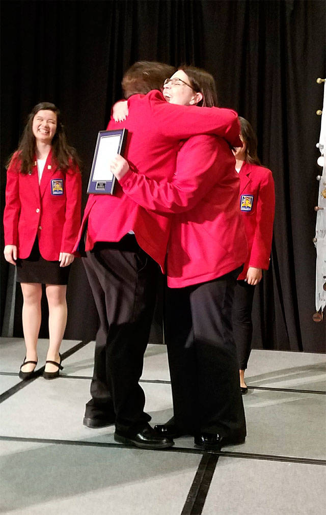 Arlington High School culinary arts teacher Teri Bravomejia hugs her son Henry during the SkillsUSA Washington State Conference. Bravomejia was recognized as the SkillsUSA Washington Advisor of the Year. (Contributed photo)