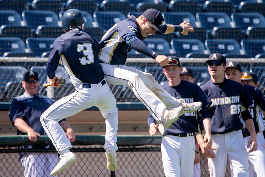 Arlingtons Trevor Kazen (left) and Jack Sheward celebrate a run against Meadowdale during a 3A district tournament winner-to-state game on May 12, 2018, at Everett Memorial Stadium. (Kevin Clark / The Herald)