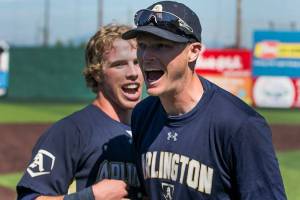 Arlingtons Gavin York (left) and Scott Striegel, Arlingtons head coach, celebrate their win for the 3A district third-place game against Meadowdale Saturday afternoon at Everett Memorial Stadium Everett on May 12, 2018. (Kevin Clark / The Herald)