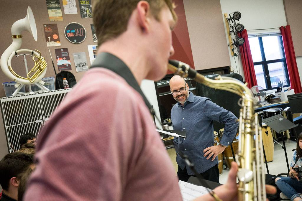 Steve Fidyk smiles during Ben Leonards saxophone solo as the Mountlake Terrace High Schools band rehearses on April 16 in Mountlake Terrace. (Andy Bronson / The Herald)