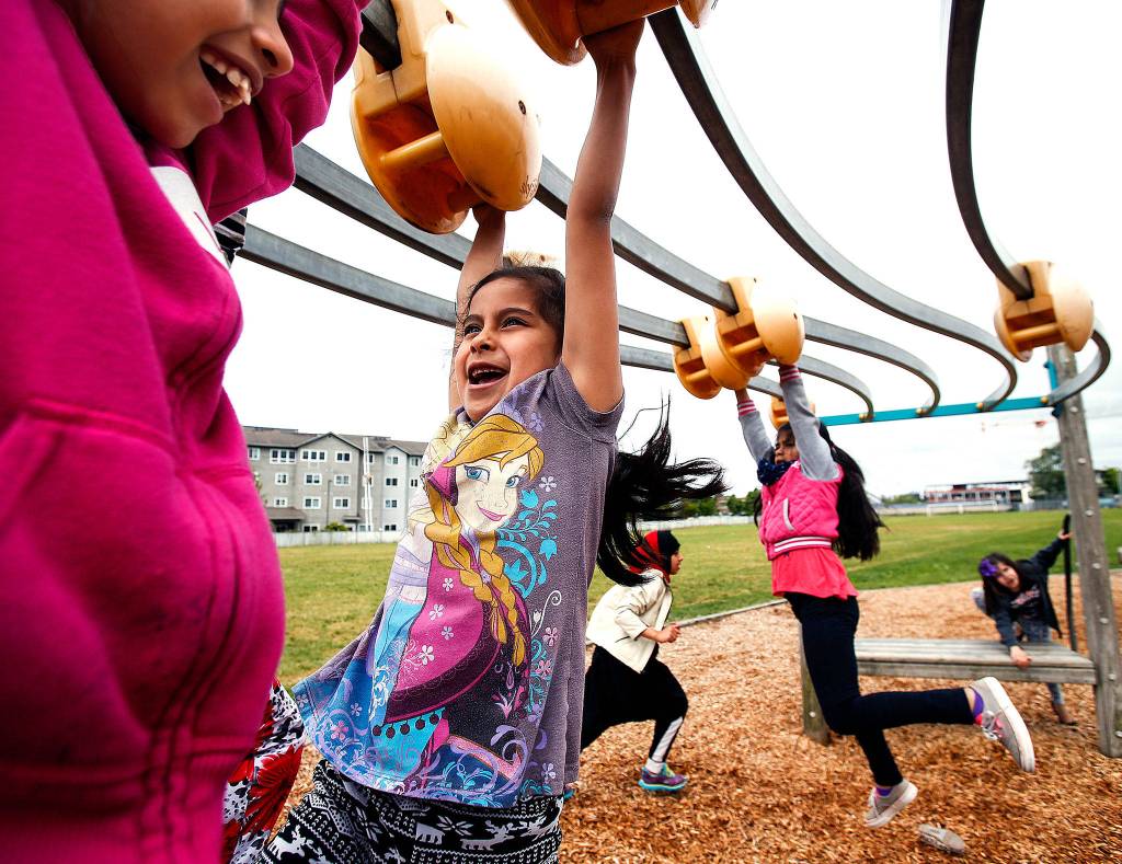 Hawthorne Elementary School kids in Everett play on a outdoor slider mounted on wood poles during recess. (Dan Bates / The Herald)