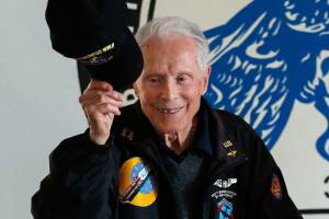 At the conclusion of his talk, 95-year-old Dick Nelms, who flew 35 missions in B-17 bombers in World War II, tips his cap to appreciative fellow military pilots at the Stanwood Eagles Thursday. (Dan Bates / The Herald)