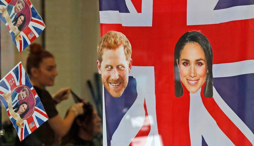 A woman gets a haircut Tuesday as the shop window is decorated with flags and pictures of Britains Prince Harry and Meghan Markle in Windsor. Preparations are being made in the town for the wedding that will take place in Windsor on Saturday. (Frank Augstein / Associated Press)
