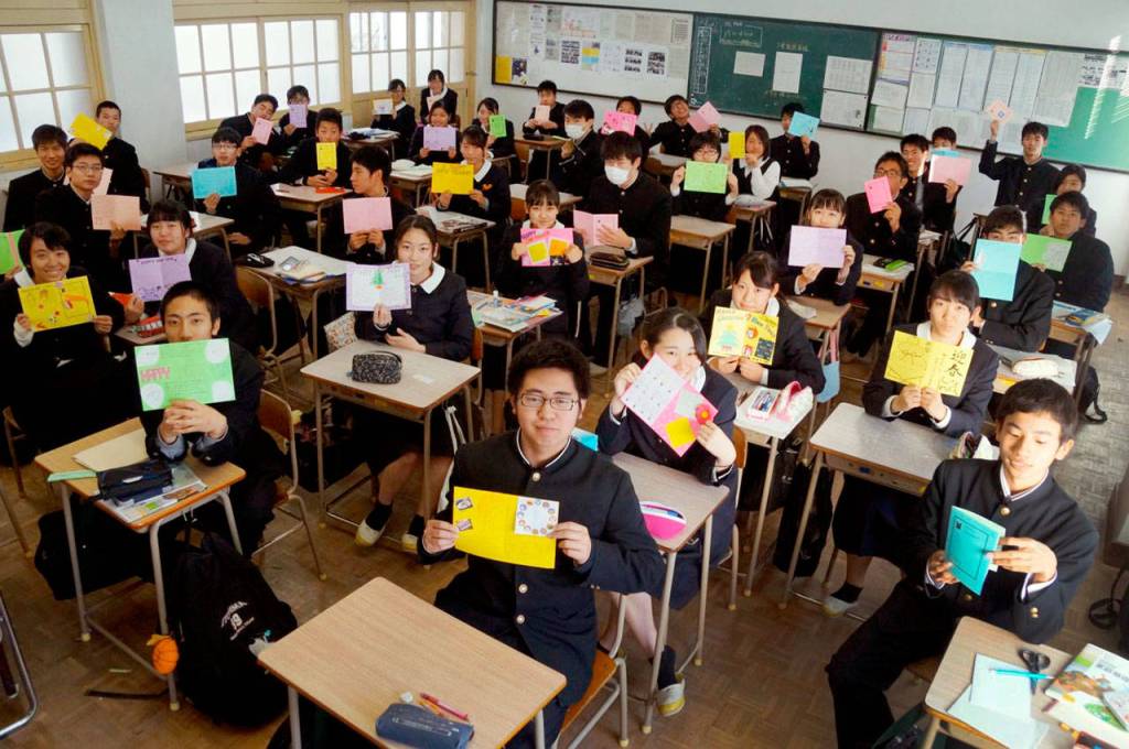 Students from​ Itoshima High School in​​ Fukuoka, Japan, show letters they made for Mariner High School students. (Toshishige Yamasaki​.)