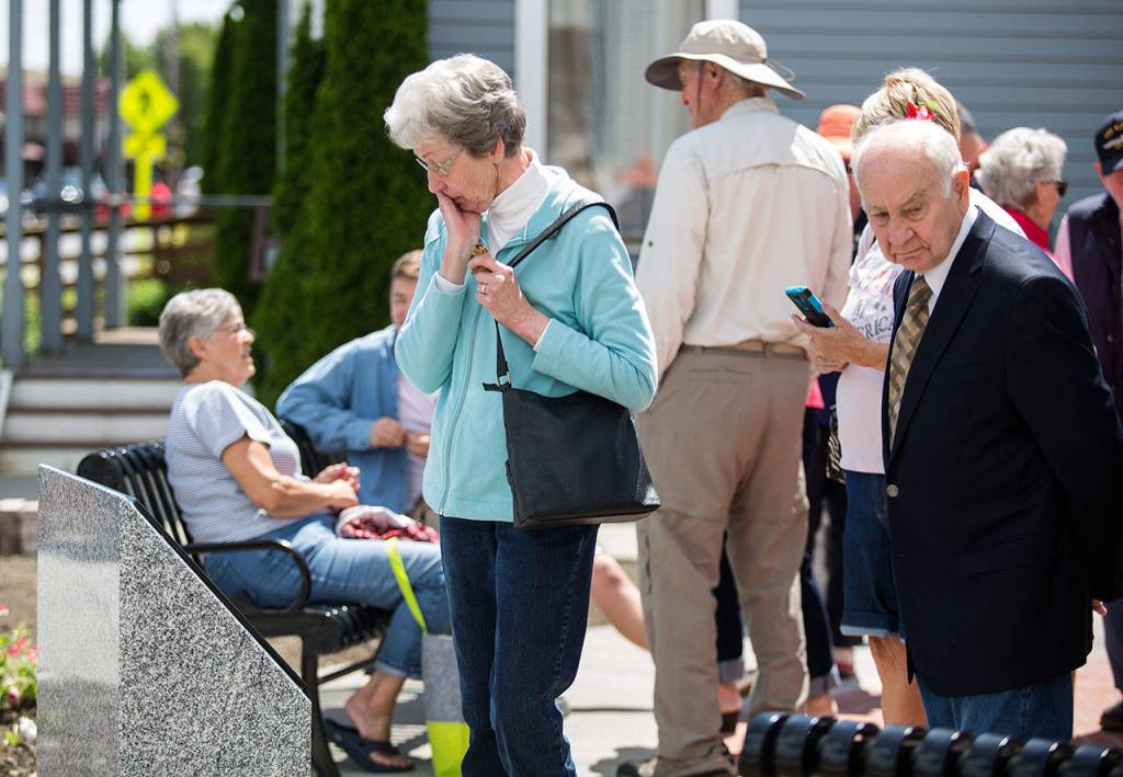 Brenda Finsen reacts as she looks at classmate George Brozs name on the Vietnam plaque in the Stanwood Area Historical Society Community Veterans Memorial at the Floyd Norgaard Cultural Center on Monday, May 28, 2018 in Stanwood, Wa. (Andy Bronson / The Herald)
