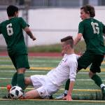 Snohomishs Liam Raney (center) slides to dislodge the ball from Redmonds Victor Araujo (left) with Redmonds Jacen Stein trailing during a state quarterfinal match on May 18, 2018, at Veterans Memorial Stadium in Snohomish. (Kevin Clark / The Herald)