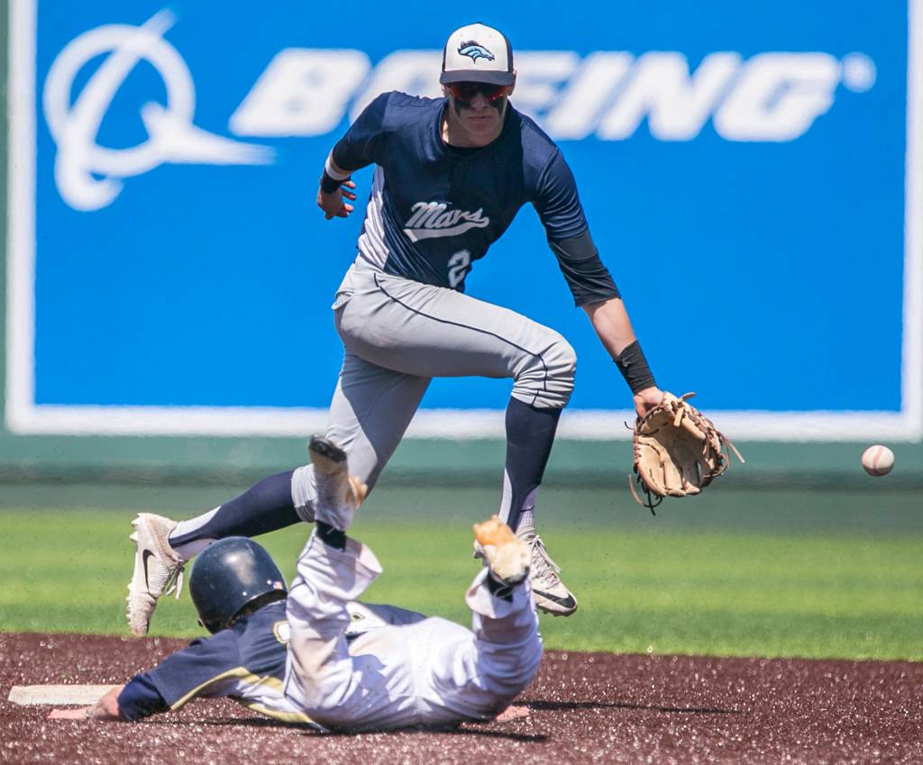 Meadowvales Will Schafer is seen missing the throw to second with Arlingtons Gavin York sliding in during the 3A district third-place game at Everett Memorial Stadium on May 12. (Kevin Clark / The Herald)
