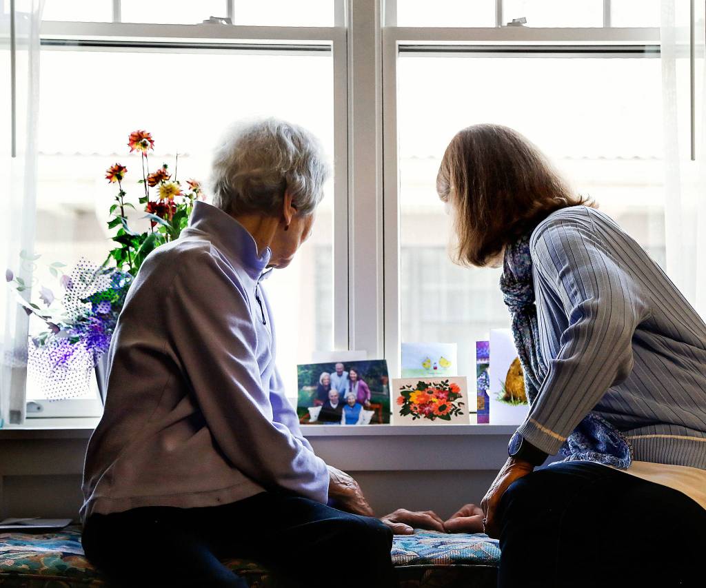 Julie Muhlstein looks at cards and pictures with her 96-year-old mother recently in her moms room at a Spokane retirement community. (Dan Bates / The Herald)
