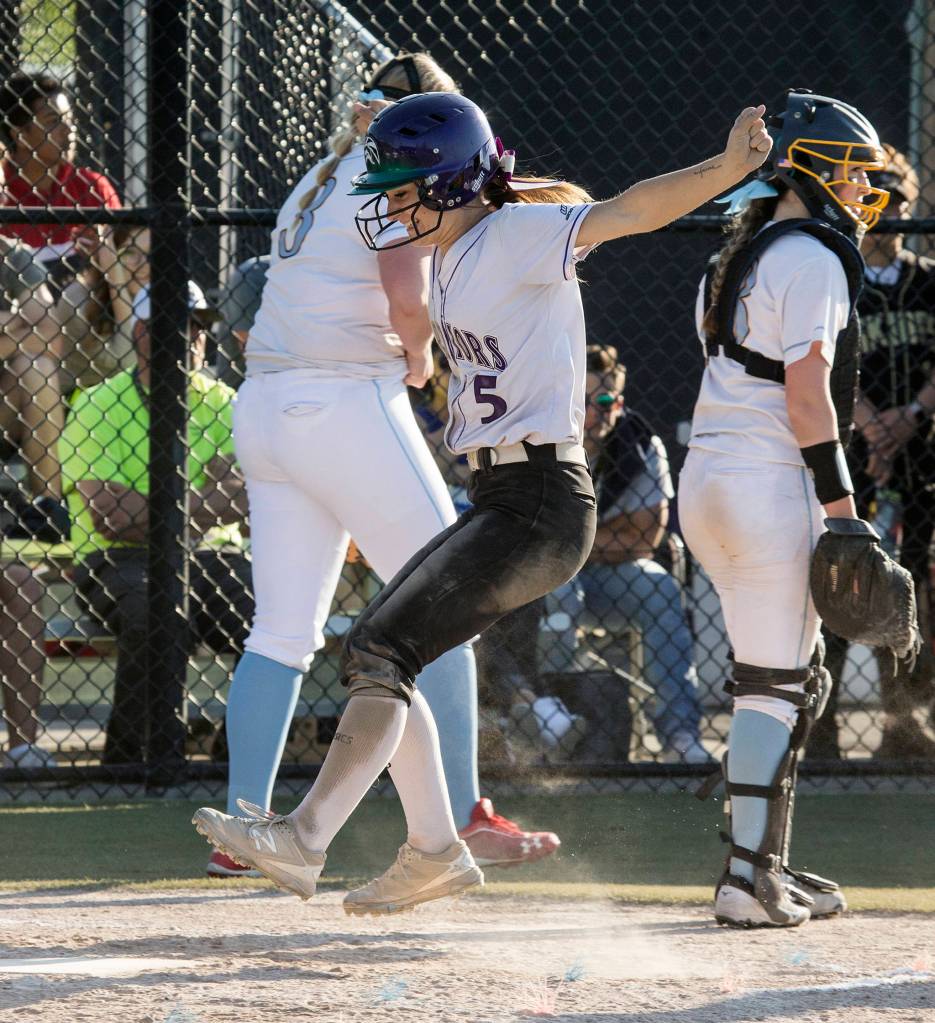 Edmonds-Woodways Gracie Boyd leaps onto home plate for a run as the Warriors beat Everett 4-3 in a 3A softball district semifinal fastpitch game at Phil Johnson Ballfields on May 15. (Andy Bronson / The Herald)