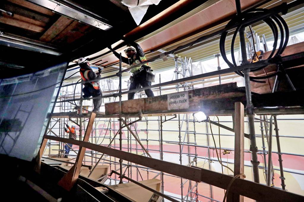 Workers stand atop scaffolding at the restaurant level of the Space Needle in Seattle on April 18. (AP Photo/Elaine Thompson)