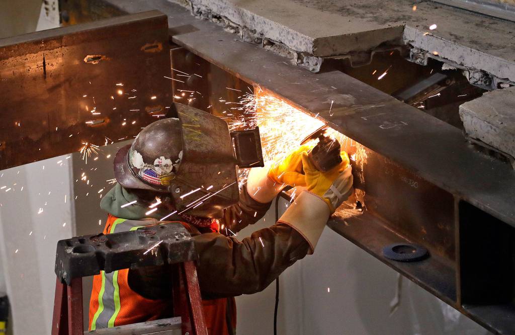 Sparks fly as a worker cuts through a steel beam for an addition of a spiral staircase in the Space Needle as work on a major remodel of the iconic observation tower continued on Feb. 7 in Seattle. (AP Photo/Elaine Thompson, file)