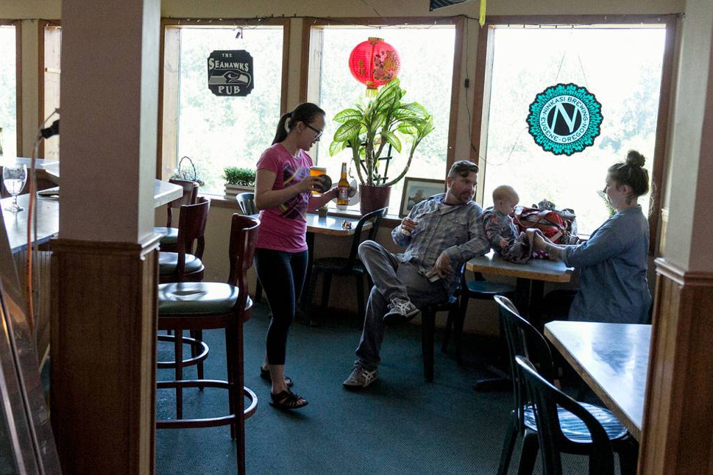 Mysa Tran, 29, delivers drinks to regulars Stevens Jenkins and Casidhe Jenkins with baby Declyn Saturday afternoon at Riverview Market & Cafe (Kevin Clark / The Herald)