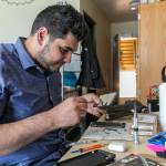 Amir Sultan repairs a phone in a dorm room at the University of Washington in Seattle. (Kevin Clark / The Herald)