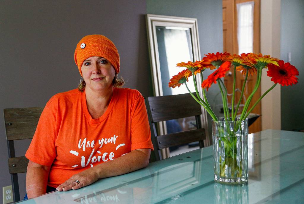 Judy Schneider-Wallace lost her first husband to suicide by gun. She is part of the Mukilteo/Lynnwood Moms Demand Action for Gun Sense in America group that will fly a large orange flag in Mukilteo through June 11, and who demonstrated Friday at an I-5 overpass and the Mukilteo Speedway in support of the Wear Orange movement to bring awareness to gun violence. (Dan Bates / The Herald)