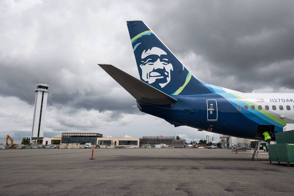 An Alaska Airlines plane undergoes maintenance near the new passenger terminal at Paine Field on May 31 in Everett. (Andy Bronson / The Herald)