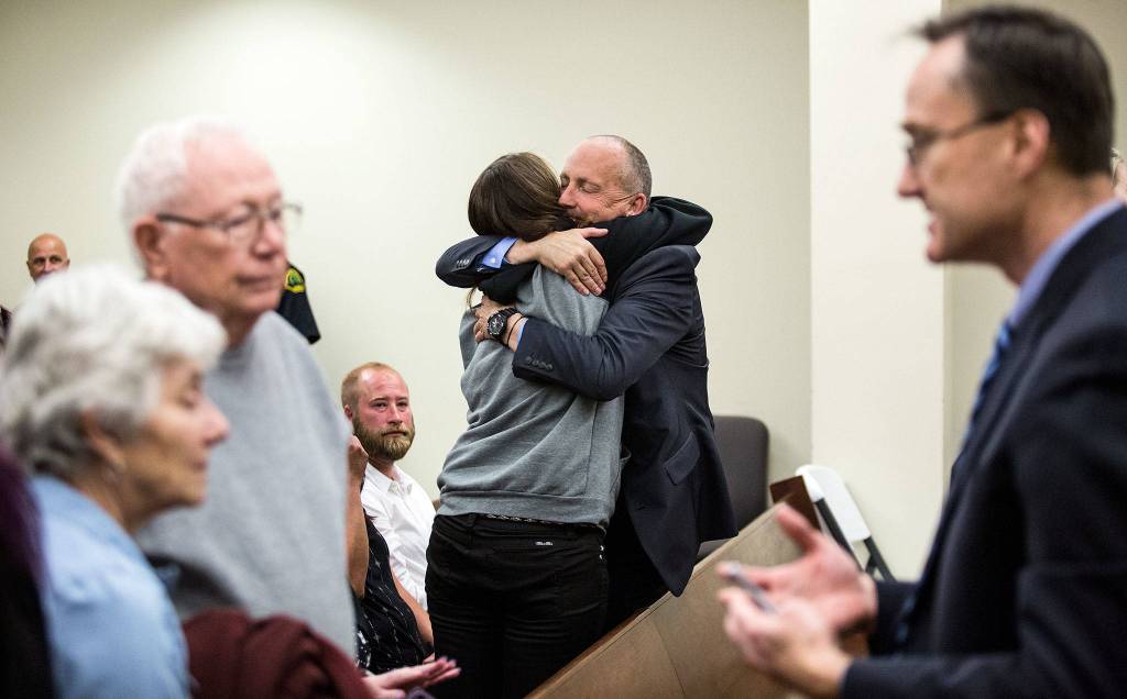 Snohomish County Detective Dave Fontenot gets a hug as Snohomish County chief criminal deputy prosecutor Craig Matheson talks with parents of Patrick Shunn after the guilty verdicts in the trial of John Reed at the Snohomish County Courthouse on May 30in Everett. Reed was convicted in the murders of Monique Patenaude and Patrick Shunn. (Andy Bronson / The Herald)