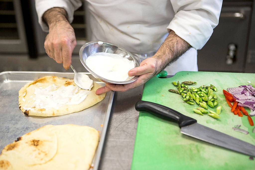Felsenstein spreads creme fraiche on his flatbread before adding smoked salmon, asparagus, red pepper, onion and cheese. (Ian Terry/The Herald)