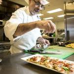 The Lynnwood Convention Centers Michael Felsenstein puts the finishing touches on a smoked salmon and asparagus flatbread. (Ian Terry / The Herald)