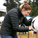 Shaylah Kugler hangs hard hats for the groundbreaking ceremony at the site of the new Everett Family YMCA Saturday morning. (Kevin Clark / The Herald)