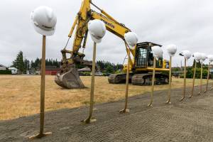 Hard hats, shovels and a back hoe decorate the site of the new Everett Family YMCA Saturday morning. (Kevin Clark / The Herald)