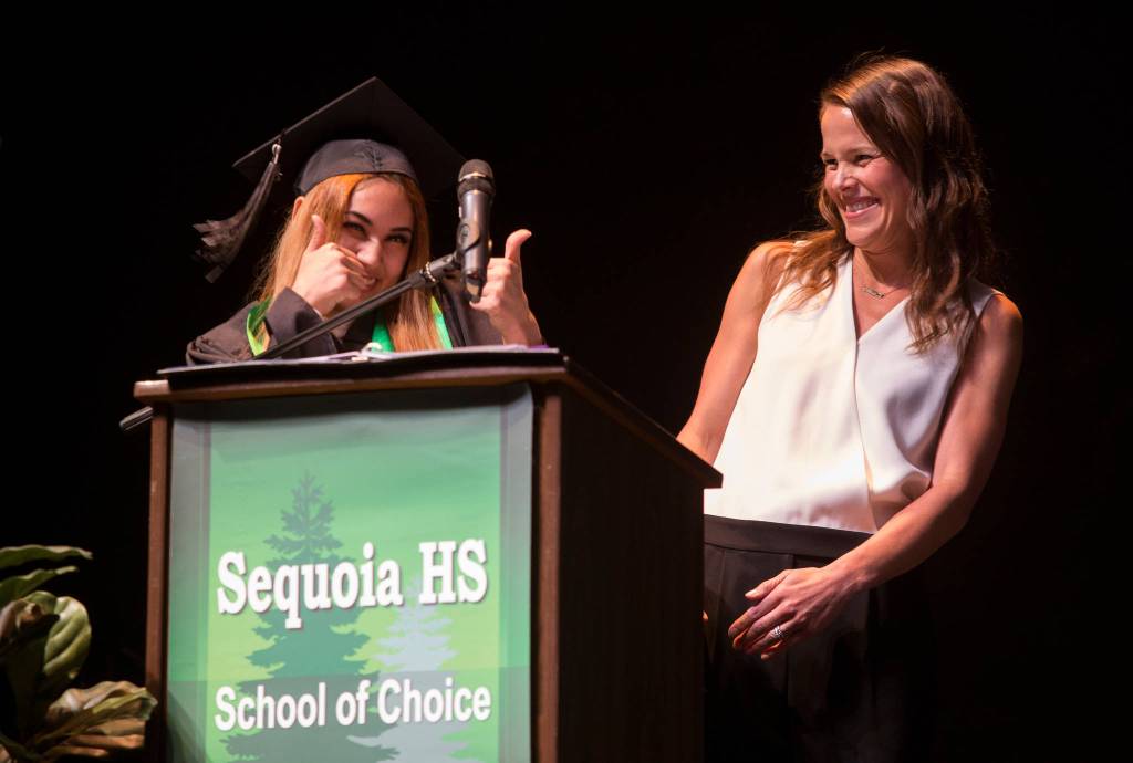 Ana Barrera gives counselor Jaimie Burton (right) two thumbs up during the Sequoia High School graduation ceremony at the Everett Civic Auditorium on Thursday. (Andy Bronson / The Herald)