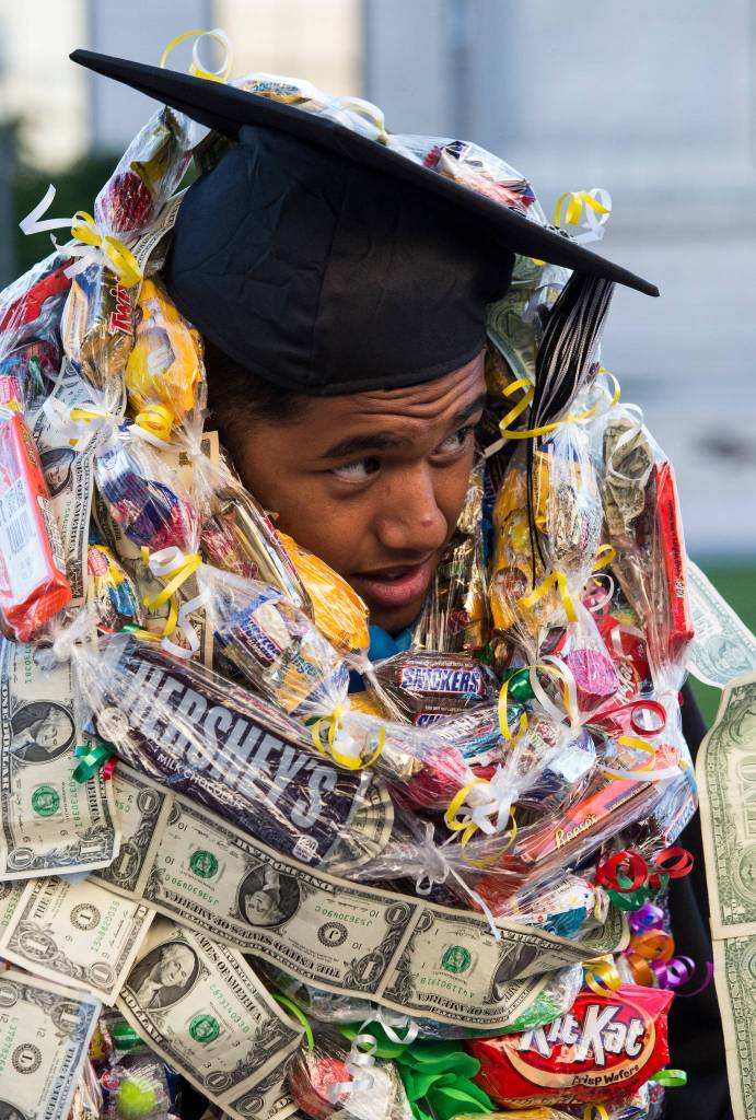 Graduate Hickner Kattil Jr. is buried under candy and money leis after the Sequoia High School graduation ceremony at the Everett Civic Auditorium on Thursday. (Andy Bronson / The Herald)